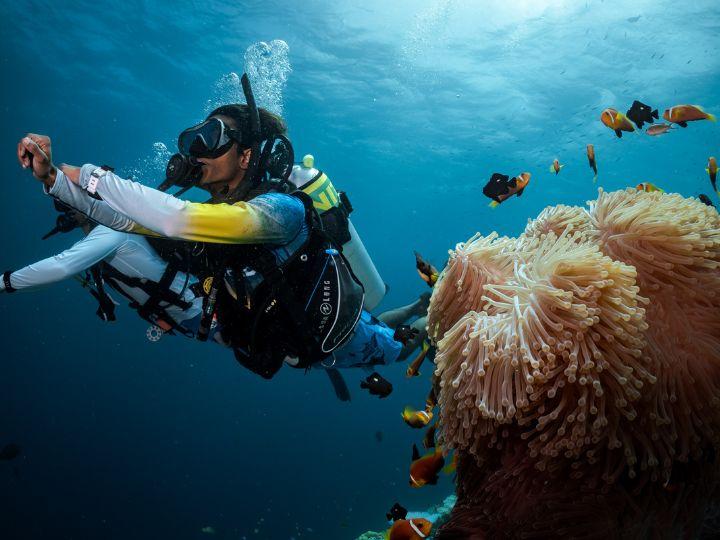 two divers underwater with nitrox tanks